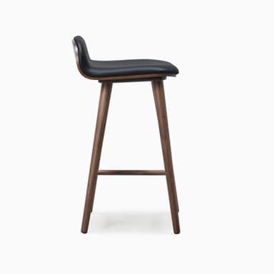 A modern bar stool featuring a black upholstered seat and backrest, supported by a splayed dark walnut wood frame with integrated footrests. — 3D model
