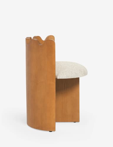 A contemporary accent chair with a distinctive scalloped wooden backrest. The chair features a U-shaped wooden base that extends upwards to form the sides of the seat support. The seat is upholstered in a textured, light-colored fabric. The overall design is minimalist and sculptural, with clean lines and geometric forms. — 3D model