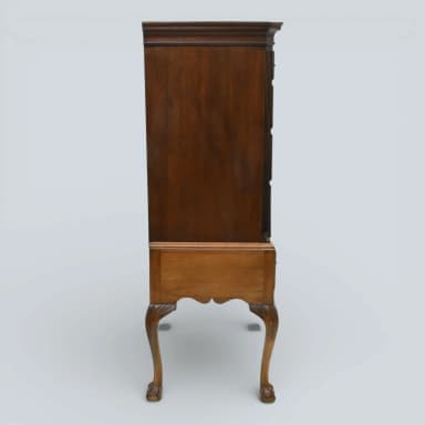 A traditional Queen Anne style highboy chest of drawers, constructed from medium-toned polished wood, featuring two stacked sections of multiple drawers with brass bail pulls, and supported by ornate cabriole legs ending in claw-and-ball feet. — 3D model