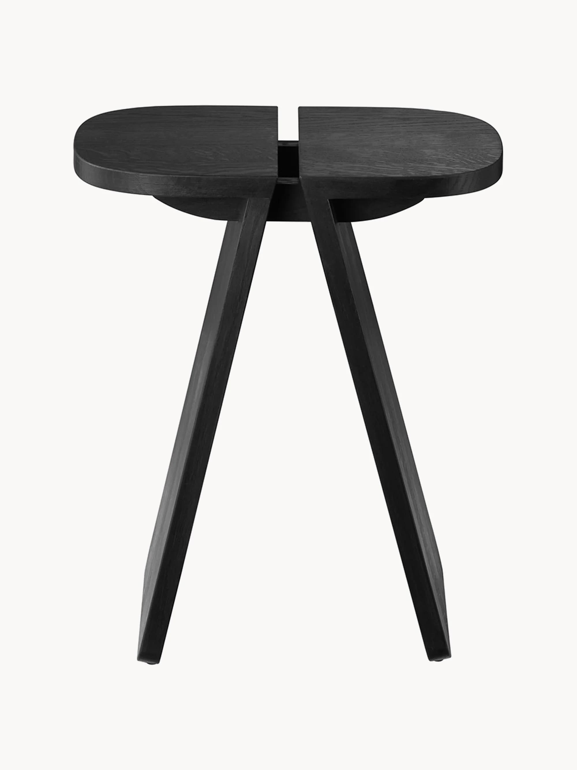 A modern side table with an organic, elongated oval tabletop featuring a central split. The tabletop is supported by a distinctive base composed of two angular, widely splayed legs that meet towards the center, creating a unique tripod-like structure where they connect to the underside of the tabletop. The overall design is minimalist and architectural. — 3D model