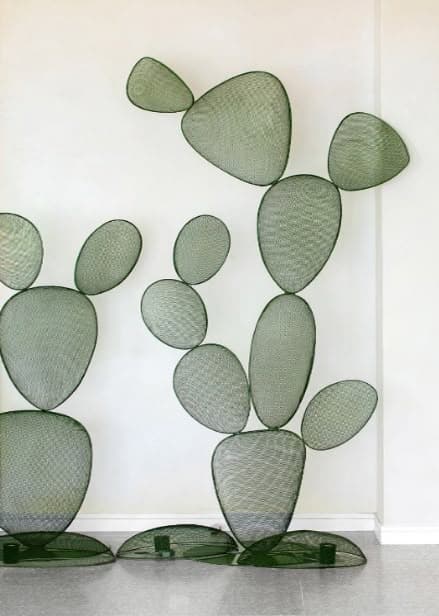 A decorative coat rack designed in the abstract shape of a cactus. It features multiple flat, oval-shaped elements of varying sizes, interconnected to form a vertical structure. The elements are constructed from a fine mesh material, giving them a lightweight and airy appearance. The base is composed of two flattened oval shapes, providing stability. The overall design is stylized and modern, mimicking the form of a prickly pear cactus. — 3D model
