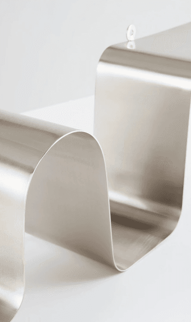 A wall-mounted shelf made from a single, continuous piece of polished metal, formed into a serpentine or wavy shape with integrated loops for hanging. — 3D model