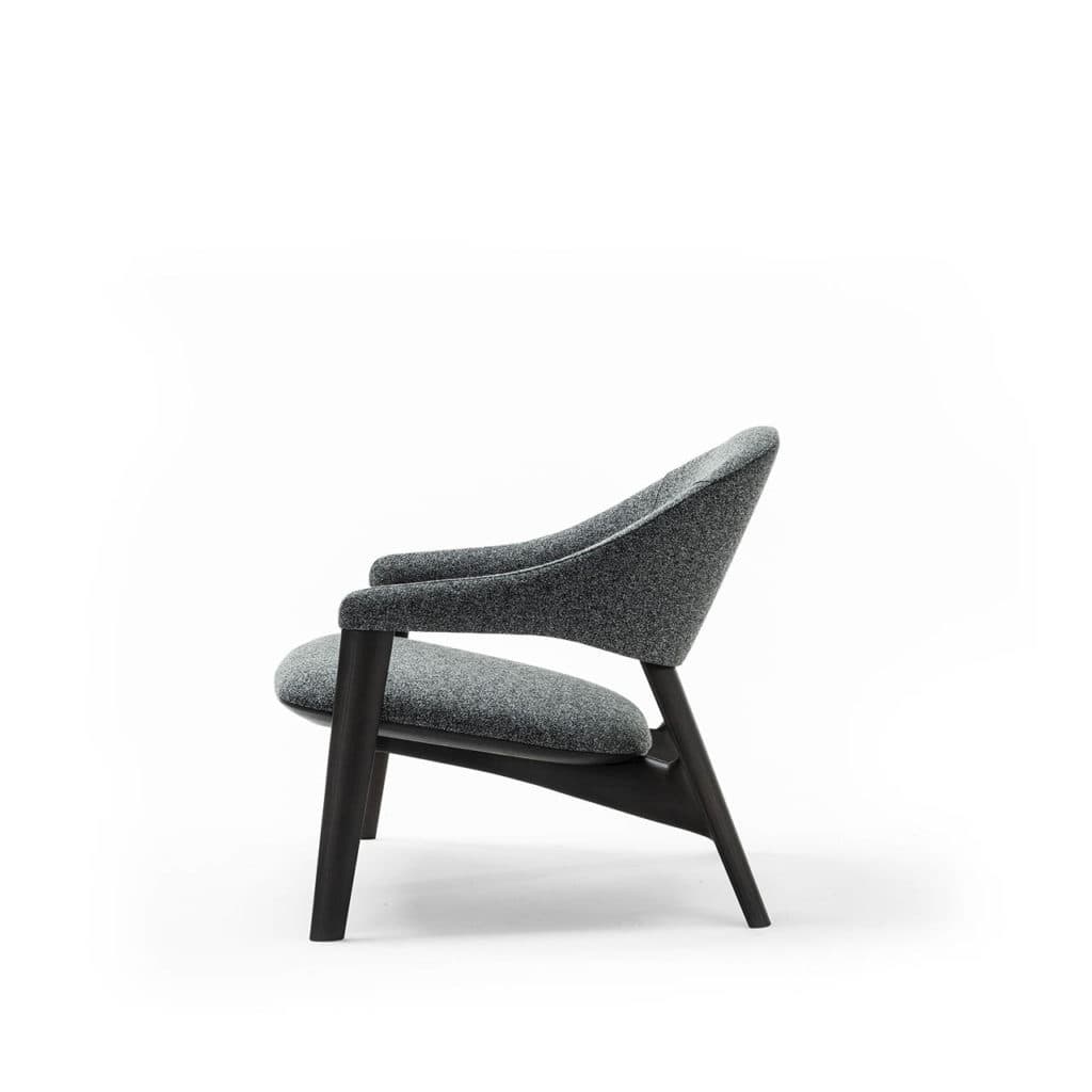 A modern armchair with a curved silhouette. The chair features a dark wooden frame and upholstered seat and back in a speckled grey fabric. The armrests are integrated into the frame, flowing from the backrest to the front. — 3D model