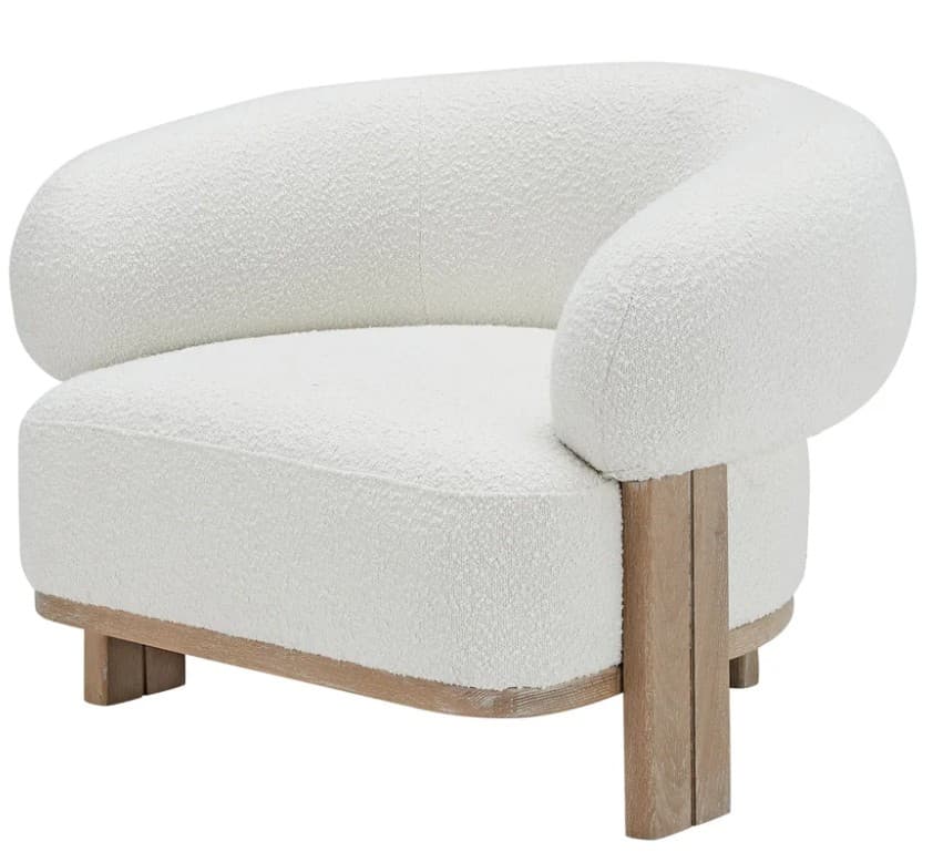 A white bouclé armchair with a curved silhouette and a wooden base. The chair features rounded armrests that blend into the backrest, creating a continuous, organic form. The base is constructed from light-colored wood, with visible grain patterns, and extends slightly beyond the upholstered body. The upholstery has a textured, looped appearance characteristic of bouclé fabric. — 3D model