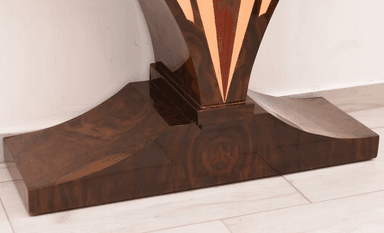 An elegant console table featuring a dark wood finish adorned with intricate marquetry. The rectangular tabletop displays a central sunburst pattern, flanked by geometric designs in contrasting lighter wood. The table's base consists of two large, sweeping curved supports that meet at a central point and transition into a sturdy, ornate plinth. These legs are also embellished with contrasting wood inlays that highlight their graceful, sculptural form. A single, small drawer with a simple pull is subtly integrated beneath the tabletop. — 3D model