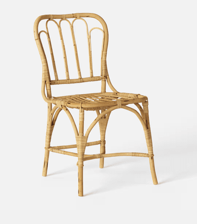 A vintage-style side chair constructed entirely from natural rattan. The chair features a curved backrest with vertical spindles and a woven seat. The legs are joined by a curved stretcher and a lower crossbar for stability. — 3D model