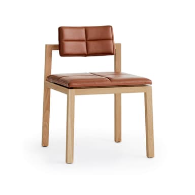 An armless chair featuring a light-toned wooden frame and cognac-colored leather upholstered seat and back cushions. Both the seat and back are divided into four square segments with visible stitching, creating a quadrille-tufted appearance. The wooden frame is simple and geometric, with straight legs and a low backrest support structure. — 3D model