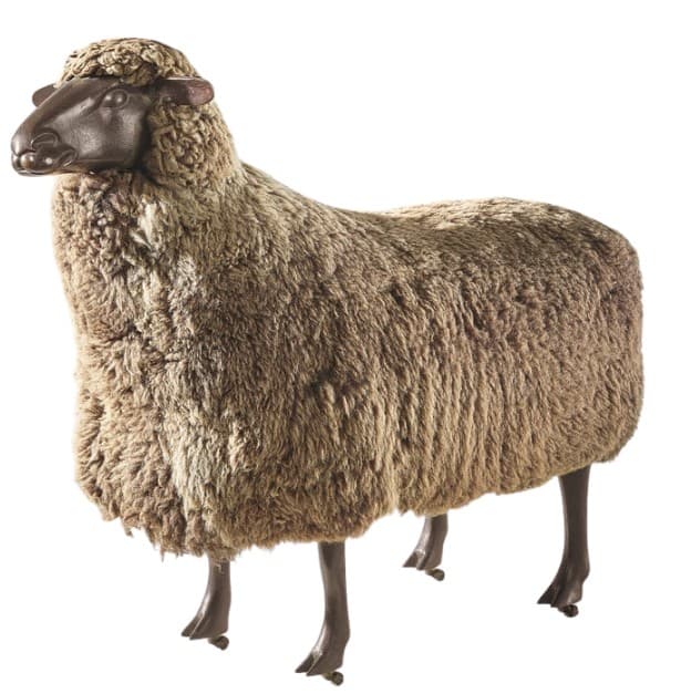 A freestanding, sheep-shaped furniture piece designed to function as an ottoman or stool. Its body is covered in a textured material resembling sheep's wool, while the head and four slender legs are smooth and dark, mimicking natural features. — 3D model
