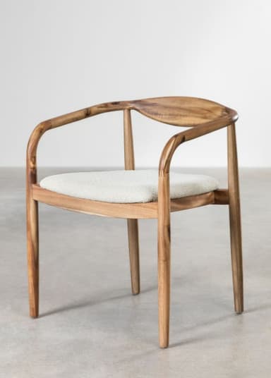 A light-toned wooden armchair featuring a distinctive curved, carved backrest that extends seamlessly into integrated armrests. The chair has an upholstered seat cushion in a light grey fabric, supported by a wooden frame with tapered legs. Its design exhibits clean lines and organic forms, characteristic of Scandinavian or mid-century modern aesthetics. — 3D model