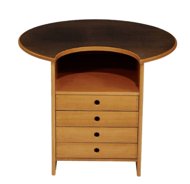A chest of drawers with an asymmetric, kidney-shaped tabletop. The tabletop is darker than the rest of the unit and appears to have a wood grain finish. The main body of the chest is made of lighter wood and features four drawers stacked vertically. Each drawer has a single circular handle. Above the drawers is an open shelf space. The overall design is modern with organic curves. — 3D model