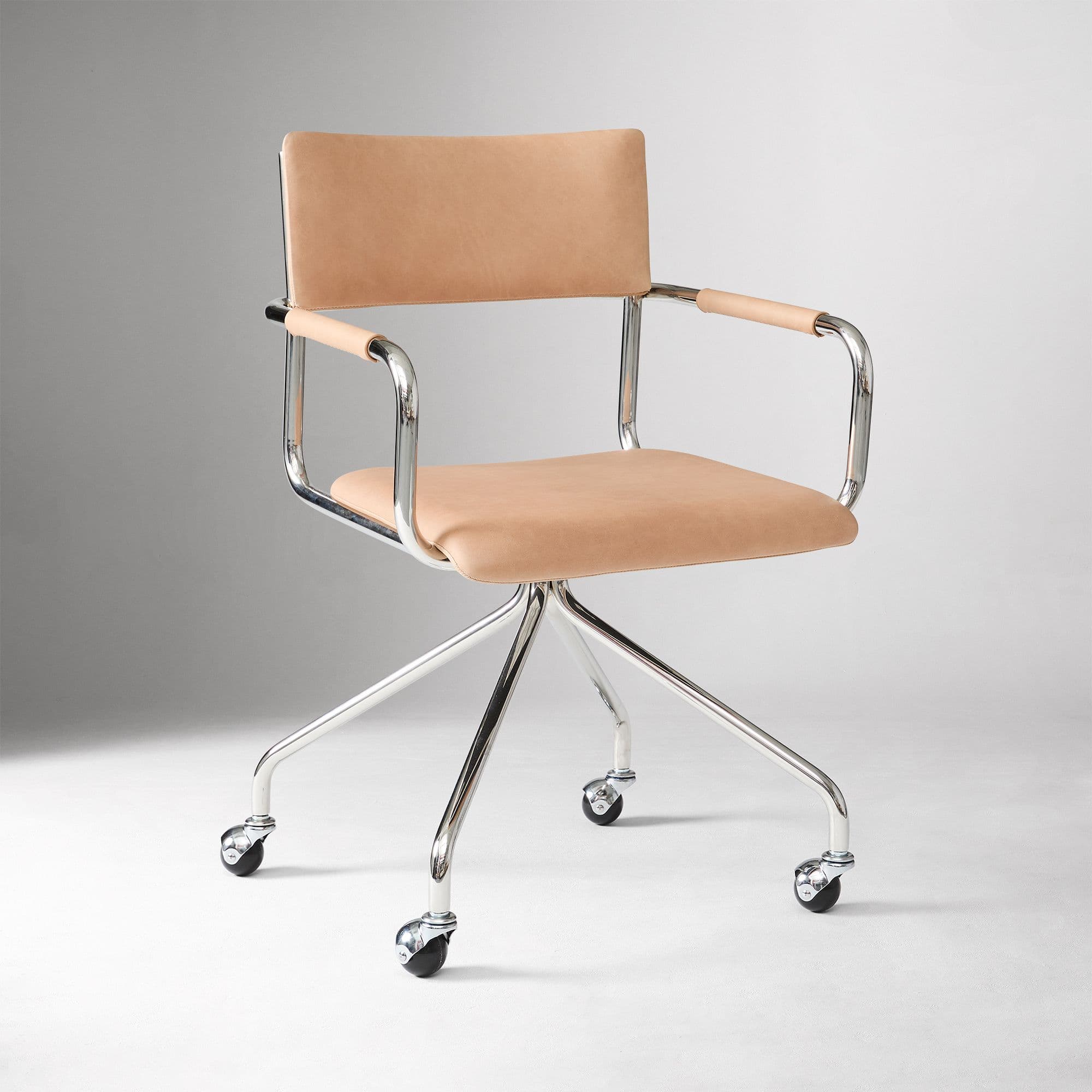 A modern desk chair featuring a polished tubular chrome frame, a natural tan leather upholstered seat and back, and a five-star swivel base with casters for mobility. The armrests are also wrapped in matching leather. — 3D model
