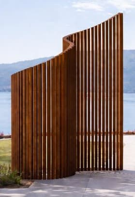 A modern, freestanding room divider constructed from numerous vertical wooden slats arranged in a distinctive curved, S-shaped configuration. — 3D model