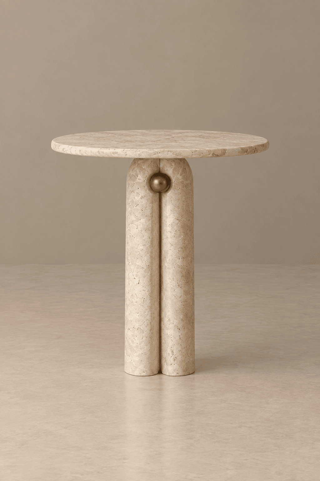 A modern round side table constructed from light beige travertine, featuring a circular tabletop and a distinctive base composed of two conjoined cylindrical columns. A brass sphere accent is embedded at the top of the base, where the columns meet under the tabletop. The table exhibits a minimalist, sculptural aesthetic. — 3D model