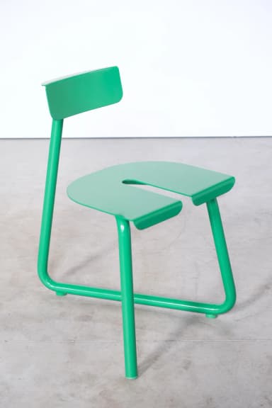 A bright green contemporary chair featuring a minimalist design. It has a distinctive U-shaped seat and a small rectangular backrest, both constructed from continuous tubular metal. The entire frame is finished in a uniform, glossy green. — 3D model