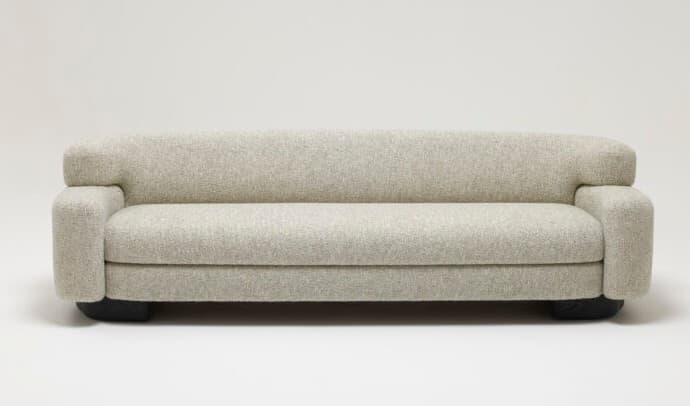 A contemporary sofa featuring a sleek, minimalist design with soft, rounded edges. It is upholstered in a light grey, subtly textured fabric and rests on a recessed dark base, giving it a floating appearance. The arms are broad and rounded, seamlessly integrating with the backrest. The seat cushion appears to be a single, continuous unit, enhancing the modern aesthetic. — 3D model