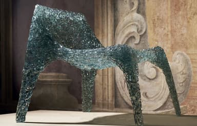 A contemporary lounge chair featuring a unique translucent, textured surface that evokes the appearance of crushed ice or sculpted glass. The chair exhibits a wide, gently reclined seat and backrest, supported by four robust, molded legs, all formed from a single continuous piece of material. — 3D model