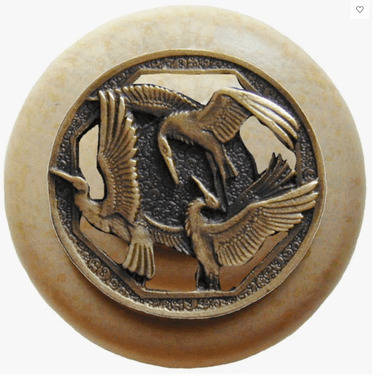 A circular decorative object featuring a central ornate metal medallion embedded into a larger, smooth disc. The medallion is crafted from a bronze-toned metal and depicts three birds (likely cranes or herons) in relief, with spread wings, set within an octagonal frame. The background of the metalwork has a textured, stippled finish. The surrounding circular disc is a light beige or cream color, with a smooth, possibly polished, surface and subtle textural variations. — 3D model