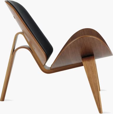 A high-quality image of a Hans J. Wegner CH07 Shell Chair, featuring a distinctive three-legged, curved plywood frame with black leather upholstered seat and back pads. The chair exhibits a light wood finish and a sleek, sculptural form against a white background. — 3D model