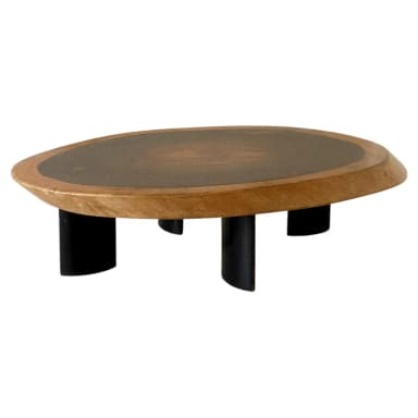A low-profile coffee table featuring an irregularly shaped, organic wooden top with a darker, recessed central panel. The table is supported by four short, stout, black-colored legs, giving it a minimalist yet distinctive appearance. — 3D model