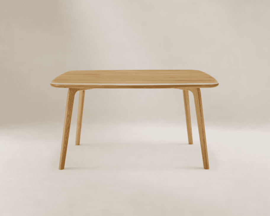 A modern, light-toned solid wood dining table featuring a rectangular top with rounded corners and four tapered, cylindrical legs. — 3D model