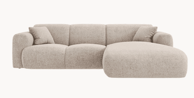 A modular sectional sofa with a chaise lounge extension. The sofa features plush, rounded armrests and a backrest divided into three distinct segments. It is upholstered in a textured fabric and includes two square throw pillows with ribbed detailing. The chaise is integrated seamlessly into the left side of the sofa as viewed from the front. — 3D model