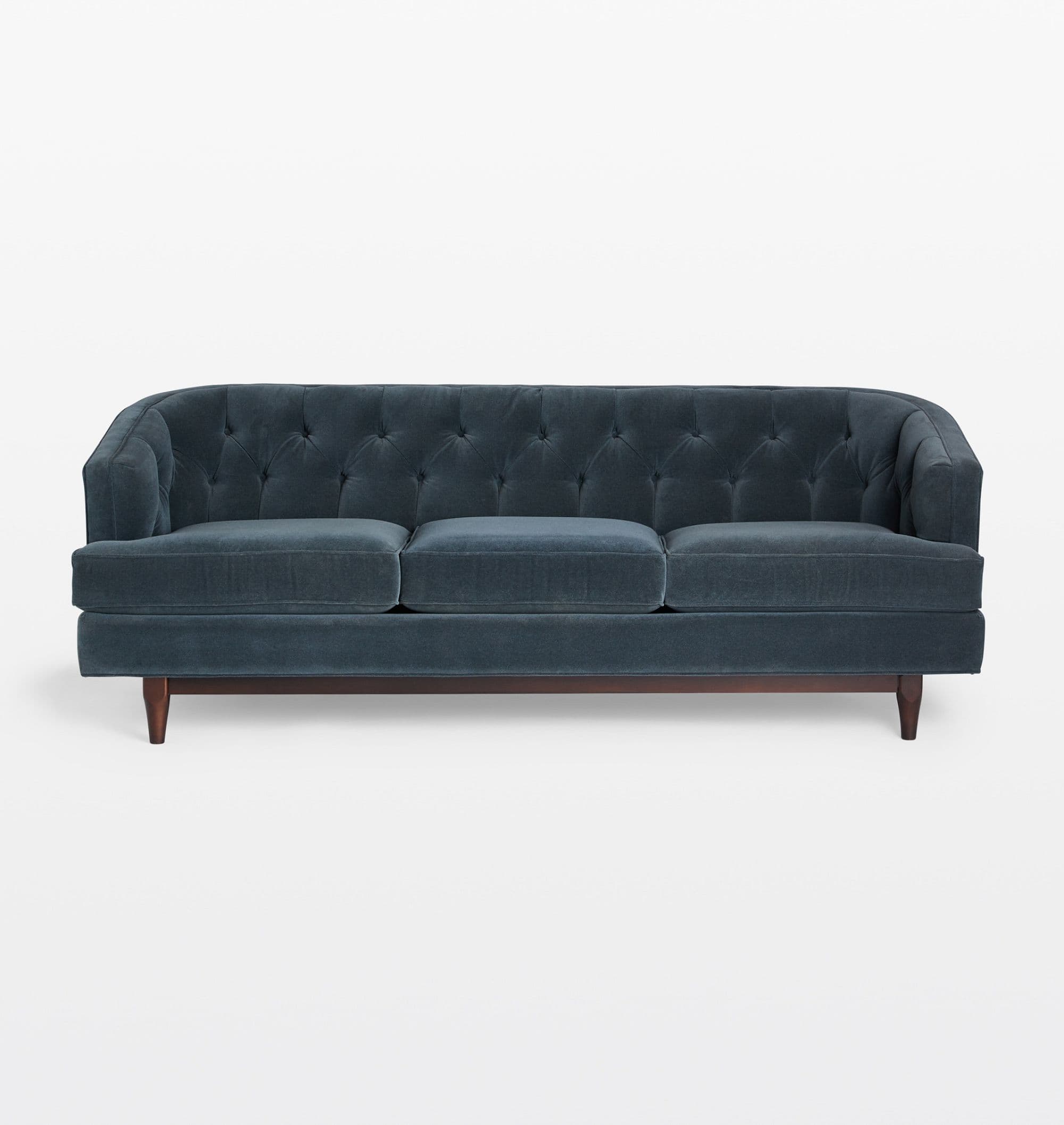 A three-seater sofa with a tufted back and seat cushions. The sofa features a rounded armrest profile and is supported by tapered wooden legs. The upholstery appears to be a dark teal or navy blue velvet fabric. — 3D model