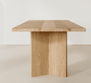 A rectangular dining table crafted from solid, light-toned oak wood, featuring a thick slab top supported by two robust, vertical panel legs. The design is minimalist and contemporary, emphasizing the natural grain of the wood. — 3D model