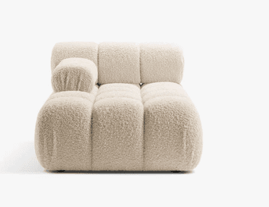 A contemporary chaise lounge featuring an innovative design with multiple rounded, pillow-like upholstered segments. The piece is finished in a light beige or off-white fabric, providing a plush and inviting aesthetic. It integrates a low backrest and a small armrest on one side, contributing to its modular appearance and ergonomic comfort. The chaise rests on discreet, low-profile feet. — 3D model