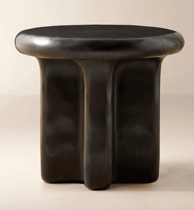 A modern side table with a rounded, irregular top and a sculpted base. The base appears to be formed from three distinct, fluid-like columns that merge towards the top. — 3D model