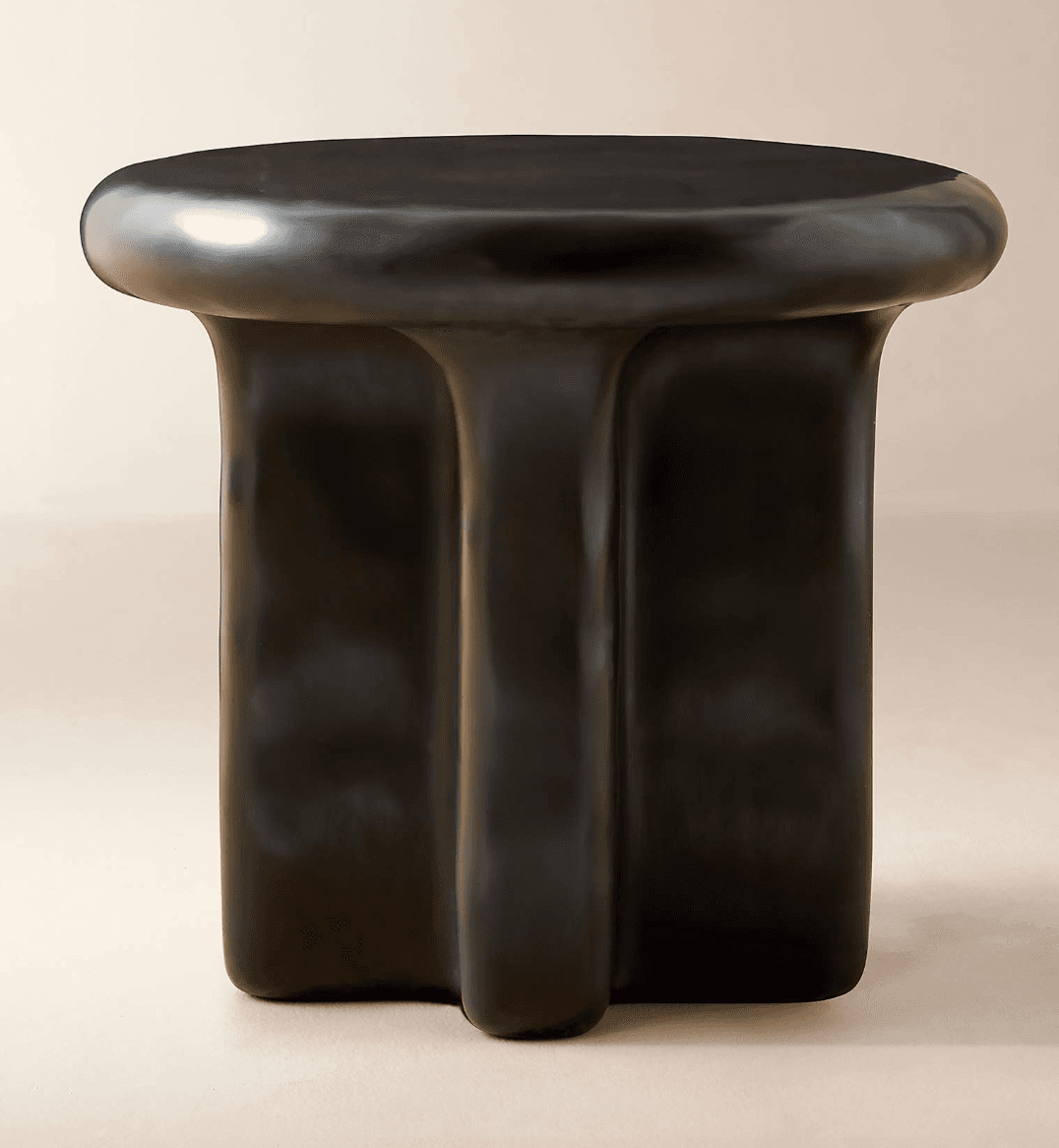 A modern side table with a rounded, irregular top and a sculpted base. The base appears to be formed from three distinct, fluid-like columns that merge towards the top. — 3D model