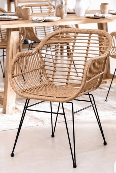 A contemporary armchair with a woven rattan seat and back, supported by a slender black metal frame with four legs. The seat and back form a continuous, rounded shell shape, with the rattan strips woven horizontally across the frame. The armrests are integrated into the rounded shape of the seat and back. — 3D model