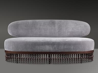 An elongated, asymmetrical chaise lounge upholstered in light grey velvet, featuring a single, organically curved backrest. The base is crafted from dark wood, showcasing a prominent border of turned wooden spindles or finials, which lends a decorative and classical touch to the overall modern form. The piece is designed for lounging or reclining. — 3D model