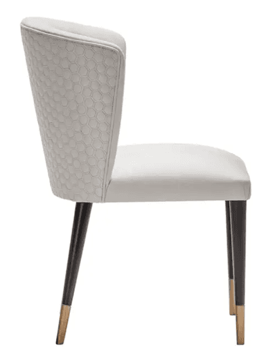 A contemporary white upholstered chair featuring a curved backrest with a distinctive hexagonal quilted pattern on its outer surface. The seat and inner back are smoothly upholstered in white. It stands on four slender, tapered dark legs, each finished with a brass-colored ferrule. — 3D model
