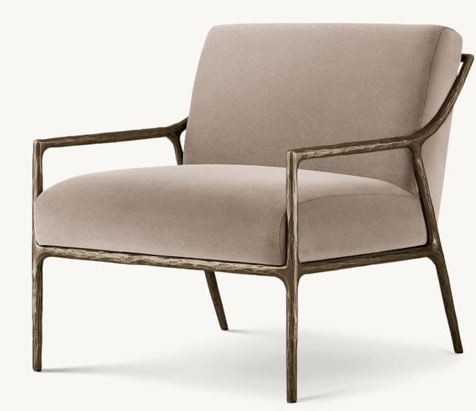A contemporary armchair with a striking, organic-inspired metal frame and upholstered seat and back. The frame features a textured, possibly cast metal finish with irregular, branching forms creating the legs and armrests. The seat and back cushions are plush and generously sized, upholstered in a soft, neutral-toned fabric. — 3D model
