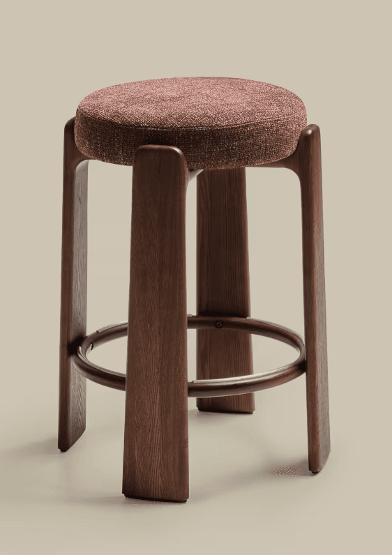 A tall bar stool featuring a round, upholstered seat atop four dark wooden legs, which are connected by a circular footrest. — 3D model