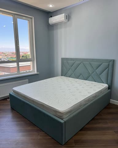 A modern upholstered platform bed featuring a distinctive geometric pattern on its headboard and a low-profile frame, presented with a white mattress. The bed frame and headboard are covered in a textured, muted blue-green fabric. — 3D model