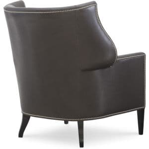 A dark brown accent chair upholstered in leather, featuring a high back with subtle wingback elements. The edges of the chair are adorned with decorative brass nailhead trim. The chair has four tapered legs made of dark wood. — 3D model