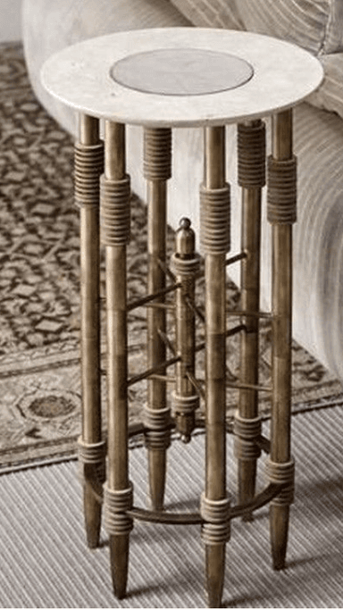 A tall, elegant pedestal table featuring a round white marble top with a subtle inset, supported by a cluster of polished brass columns. The brass columns are adorned with textured rope-wrapped accents at the top and bottom, and a decorative, cross-braced brass element at the mid-section adds structural and visual interest. — 3D model