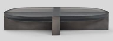 A contemporary coffee table featuring an oblong, dark translucent (smoked glass or acrylic) top with smoothly rounded edges, supported by a central, rectangular base made of a dark-finished material, likely metal or wood. The overall aesthetic is minimalist and sleek. — 3D model