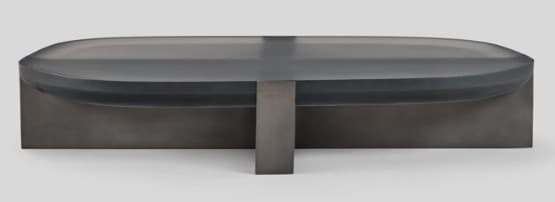 A contemporary coffee table featuring an oblong, dark translucent (smoked glass or acrylic) top with smoothly rounded edges, supported by a central, rectangular base made of a dark-finished material, likely metal or wood. The overall aesthetic is minimalist and sleek. — 3D model