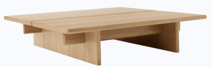 A minimalist, low-profile coffee table crafted from light-colored natural wood, likely oak. The tabletop consists of two parallel planks, slightly separated, resting on a sturdy base composed of two solid, L-shaped wooden supports. The design emphasizes clean lines and a simple, geometric form, highlighting the natural grain and texture of the wood. The table appears to be new and in excellent condition, presented on a white background. — 3D model