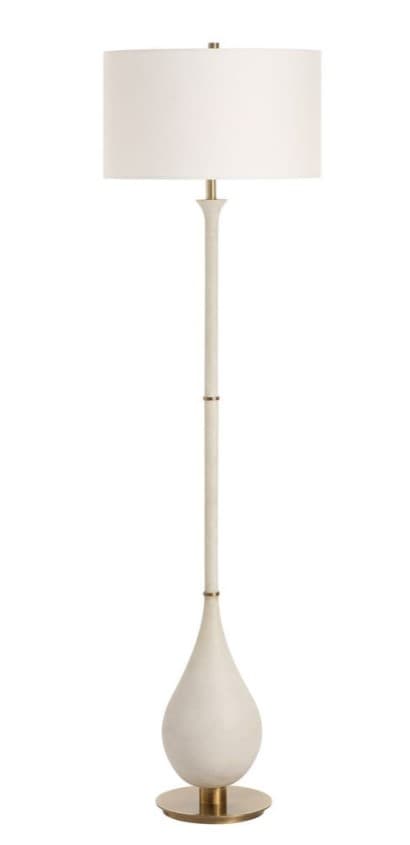 A floor lamp with a drum-shaped lampshade in a white fabric. The lamp stand is composed of a teardrop-shaped base with a brass accent at the bottom, a tall, slender, segmented stem with brass accents, and a decorative finial at the top. — 3D model
