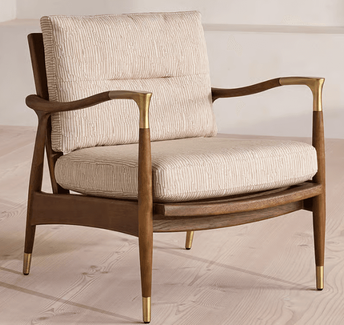 A mid-century modern inspired lounge chair featuring a sturdy exposed dark wood frame, comfortable light-colored upholstered cushions, and elegant brass accents on the armrests and tapered legs. — 3D model