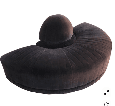 A contemporary, curved sofa upholstered in a dark grey or charcoal velvet fabric, featuring prominent channel tufting across its entire surface. The sofa has a distinctive spherical or dome-shaped backrest element integrated into its center, providing a unique visual focal point. Its form suggests a plush and luxurious seating experience. — 3D model
