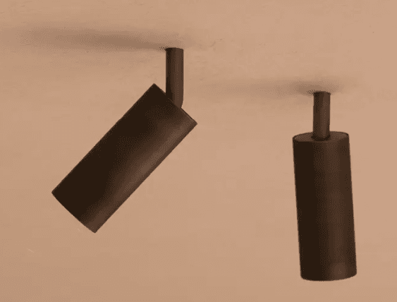 Two dark, cylindrical light fixtures mounted to a ceiling. One is angled downwards, and the other is oriented perpendicularly to the ceiling surface. They exhibit a matte finish and a minimalist design, suggesting they are modern spotlights. — 3D model