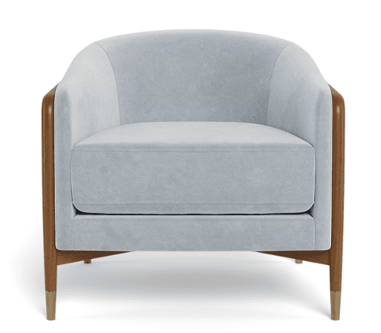 A upholstered armchair with a rounded back and arms, featuring a wooden frame visible on the sides and legs. The upholstery appears to be a soft, light blue fabric. The legs are made of wood and have brass-colored accents at the feet. The seat cushion is separate from the frame, and the back is a continuous curve. — 3D model