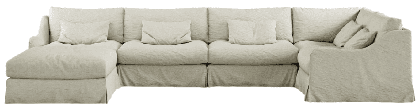 A sectional sofa with a chaise lounge and multiple seating modules, upholstered in a light-colored, textured fabric. The sofa features loose slipcovers that give it a relaxed, somewhat wrinkled appearance. It includes several throw pillows for added comfort and support. The base of the sofa is skirted. — 3D model