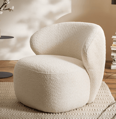 A contemporary lounge chair upholstered in a textured, cream-colored bouclé fabric. The chair features a distinctive, organic silhouette with a rounded back that seamlessly transitions into the armrests and seat, creating a unified and inviting form. Its low profile and plush cushioning suggest comfort and relaxation, making it a statement piece for modern interiors. — 3D model