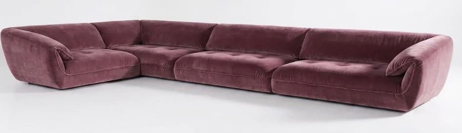 A large L-shaped modular sectional sofa upholstered in plush mauve velvet. It features a low profile with a continuous base, button-tufted seat cushions, and gently curved, folded armrests on either end. The design suggests a contemporary and luxurious aesthetic. — 3D model