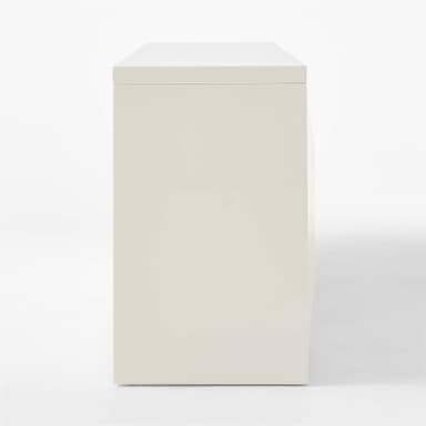 A white sideboard with a geometric, faceted design on its four doors. The doors are aligned in two pairs, creating a symmetrical facade. The sideboard has a clean, modern aesthetic with a simple rectangular silhouette and is supported by short, blocky feet. — 3D model